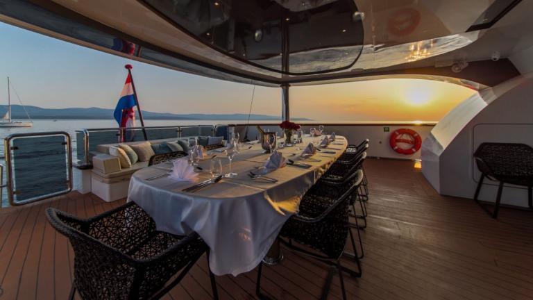 Dining and living area on the aft deck of luxury sailing yacht Omnia image 1