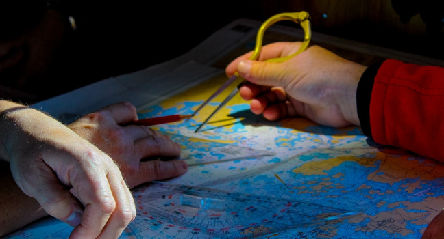 Segelrouten und Windrichtungen – Navigation zwischen Bodrum und Marmaris Zwei Segler planen mit einer Seekarte ihre Route zwischen Bodrum und Marmaris entlang der türkischen Küste.