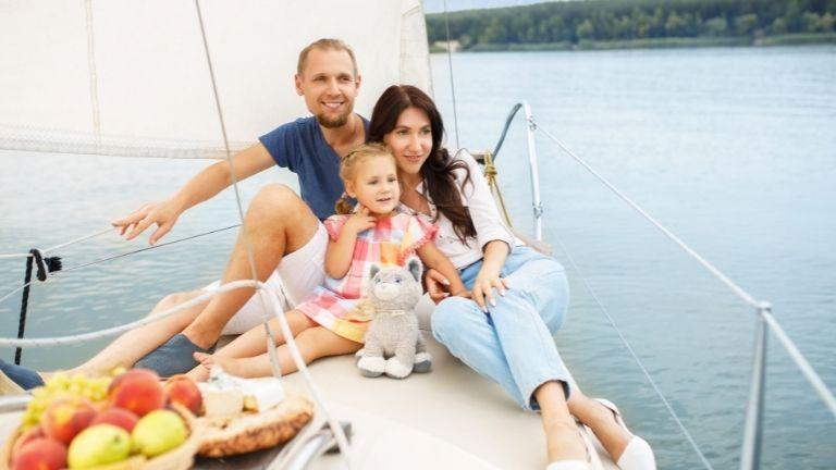 Familie genießt den Sommerurlaub auf einem Segelboot, umgeben von Natur und Ruhe.