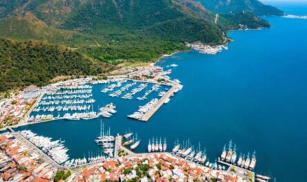 Der Marmaris Yacht Hafen zeigt zahlreiche Yachten und Boote, die in einem malerischen Hafen vor grünen Hügeln und dem blauen Meer vertäut sind