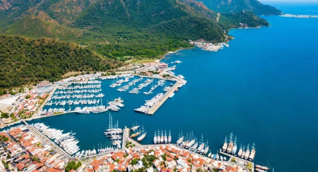 Der Marmaris Yacht Hafen zeigt zahlreiche Yachten und Boote, die in einem malerischen Hafen vor grünen Hügeln und dem blauen Meer vertäut sind