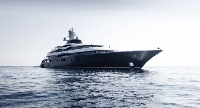 A luxury mega yacht anchored on calm open sea under soft daylight