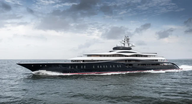 A sleek black and white luxury yacht cruising fast through open waters