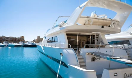 Luxury yacht docked at a modern marina under clear blue skies