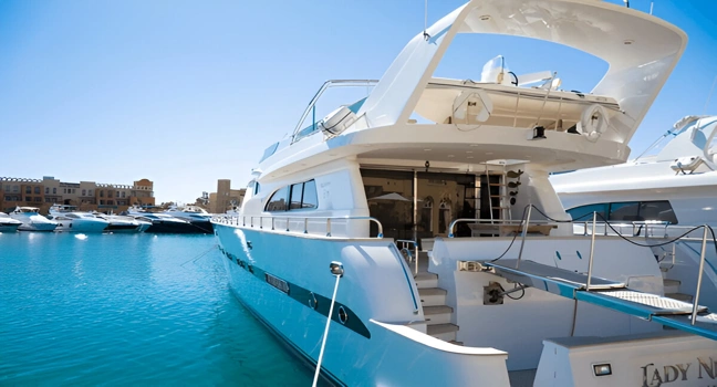 Luxury yacht docked at a modern marina under clear blue skies