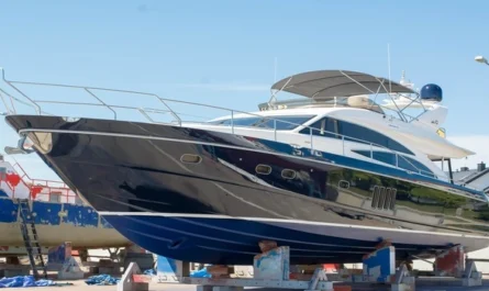 A sleek black and white luxury yacht positioned on dry dock for maintenance and repairs