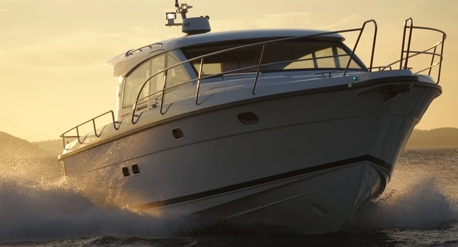 A modern motor yacht speeding across the sea during a golden sunset with ocean spray rising