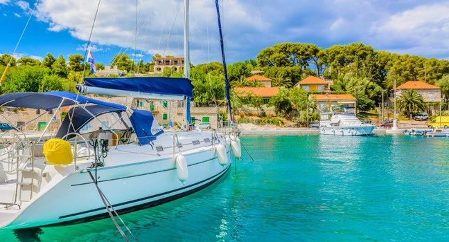 Segelyacht in kroatischem Hafen mit klarem Wasser.