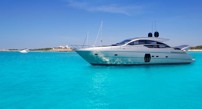 A luxury motor yacht floating in crystal-clear turquoise sea