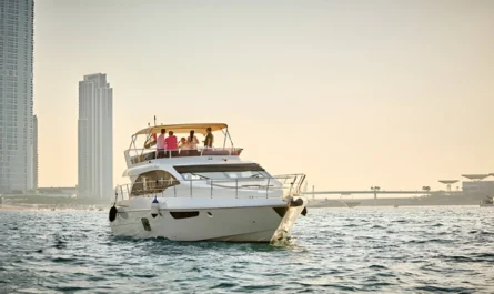 A group of people enjoying a sunset yacht cruise near the Dubai skyline