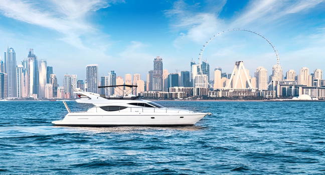A modern white yacht cruising with Dubai skyline and Ain Dubai in the background