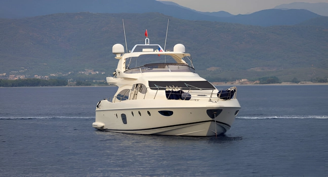 A luxurious motor yacht seen from the front cruising on a peaceful blue sea Yacht Charter Rentals