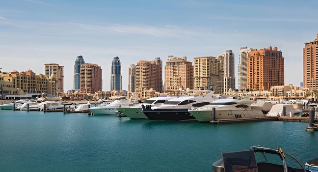 A row of luxury yachts docked in turquoise waters with Doha skyscrapers behind Yacht Charter Rental Dubai