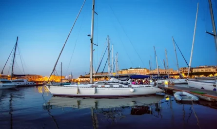 Sailing yachts resting at a peaceful marina under blue hour twilight lighting