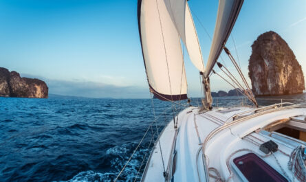 Eine Bavaria Segelyacht fährt bei ruhigem Wind über das offene Meer mit Felsinseln im Hintergrund