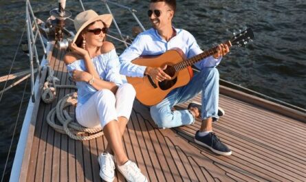 Paar spielt Gitarre und entspannt auf einer Yacht – Stimmung eines Musikfestival-Wochenendes auf dem Wasser