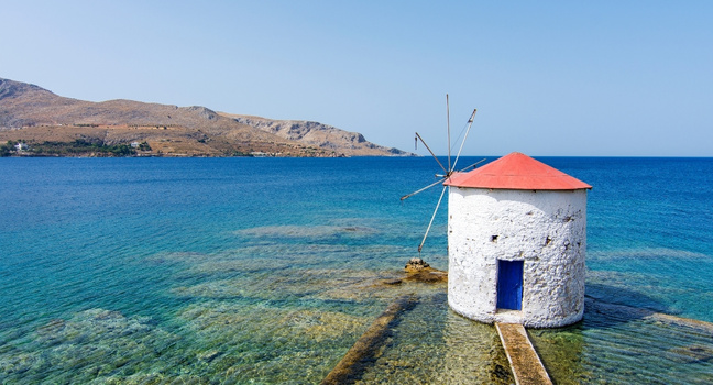 Windmühle auf der Dodekanes Insel Leros direkt am Meer mit Blick über die stille Ägäis