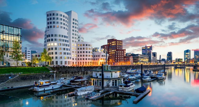 Yachthafen im Düsseldorfer Medienhafen mit den markanten Gehry-Gebäuden und Booten im warmen Abendlicht
