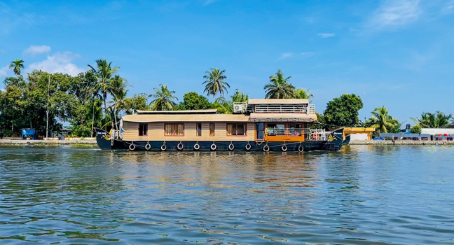 Holz-Hausboot auf einem ruhigen Wasserweg in Holland mit Palmen und blauem Himmel