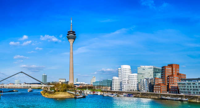 Blick auf den Düsseldorfer Medienhafen mit Rheinturm und Wasserwegen, idealer Startpunkt für Partyboote und Bootstouren