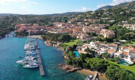 Blick auf einen Yachthafen mit Segelbooten entlang einer Küste – Symbol für die Wahl der richtigen Bootsgröße je nach Route