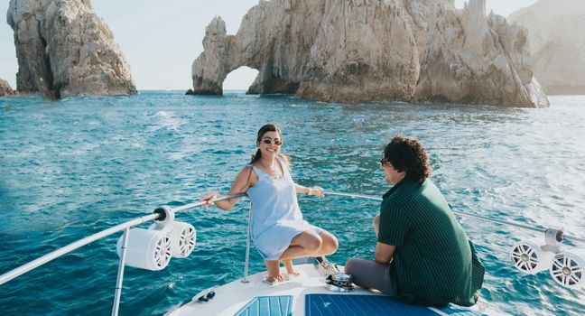 Welche Yacht ideal für zwei Personen ist Paar entspannt auf einer kleinen Yacht vor Felskulisse – ideale Größe für zwei Personen