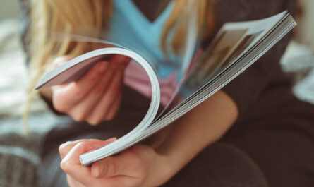 Person blättert in einem Yacht Magazin und liest die Inhalte durch