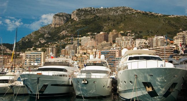 Welche Yachten für Fotoshootings geeignet sind Mehrere große Yachten liegen im Hafen vor einer Stadtkulisse – ideale Modelle für professionelle Fotoshootings