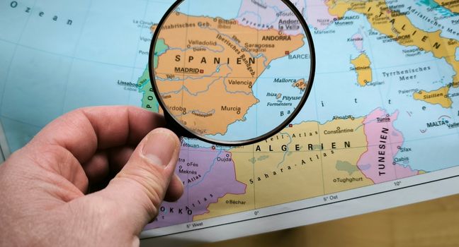 Route und Wetter für Yachtreise planen Karte von Spanien mit Lupe – Symbol für Planung, Wetteranalyse und nachhaltiges Reisen.