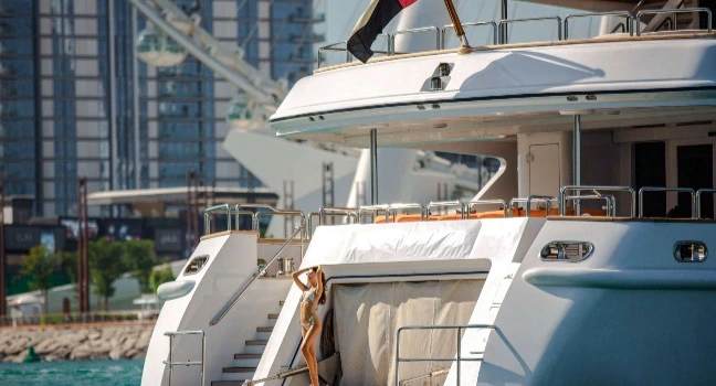 Benetti Yacht Details im Hafenbereich Detailansicht einer Benetti Yacht mit Heckbereich und urbanem Hafen im Hintergrund