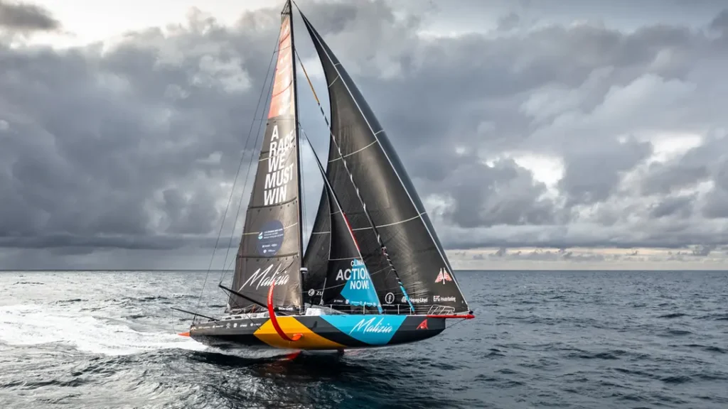 Die Yacht Team Malizia segelt über den Ozean unter dunklen Wolken während einer internationalen Hochseeregatta.