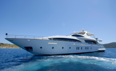 Front view of a white motor yacht on the blue sea