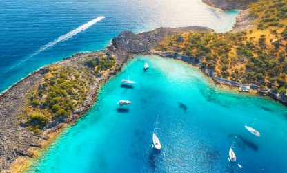 Синее море, острова и лодки на побережье Эгейского моря в Бодруме.