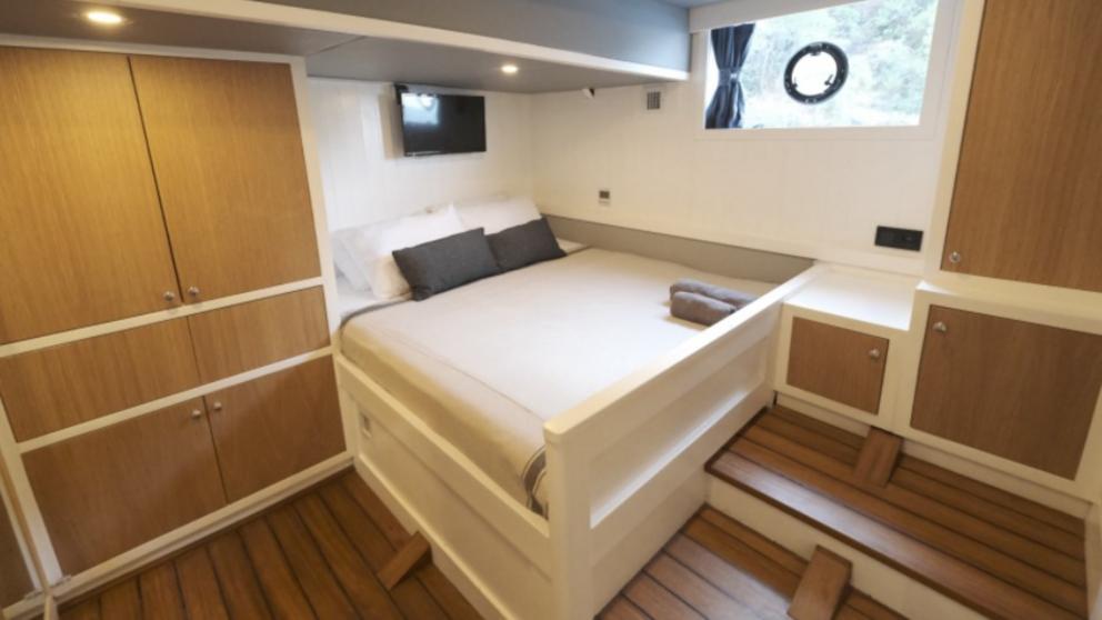 Bed, wardrobe and TV in the bedroom on the yacht