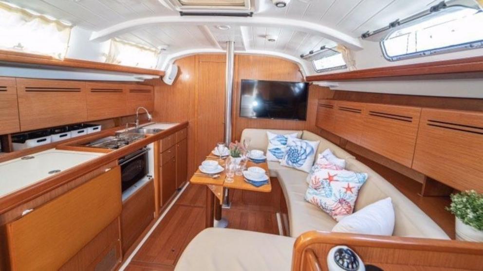Cozy atmosphere in the saloon on the Freya yacht. You can see beige sofas with cushions