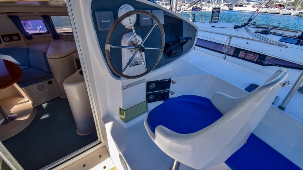 Position of the navigator on the catamaran. Armchair and chrome steering wheel can be seen