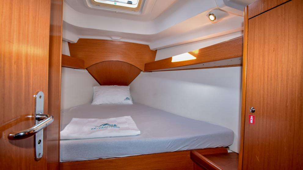 Double cabin with porthole on a sailing yacht and large bed