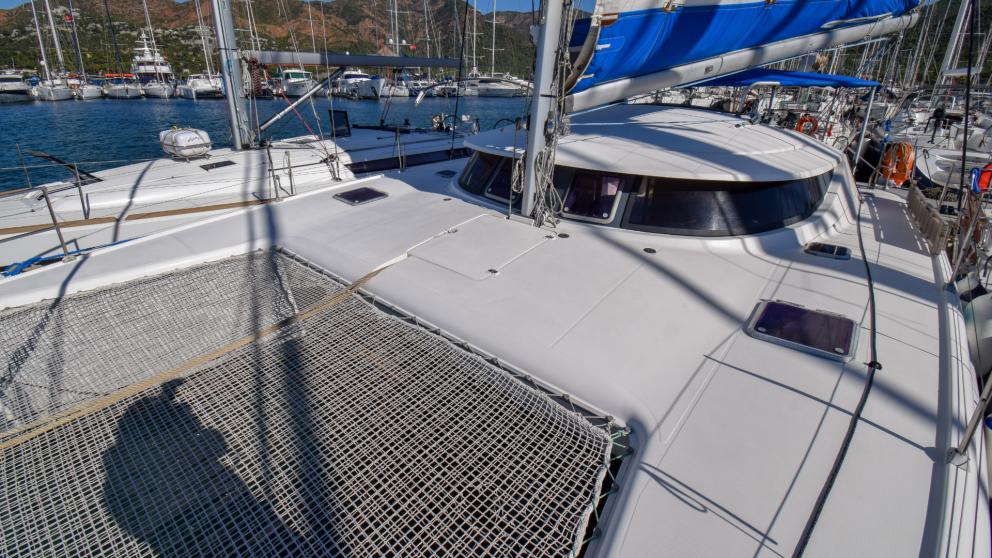 The bow of a moored catamaran. The stretched mesh between the sides can be seen