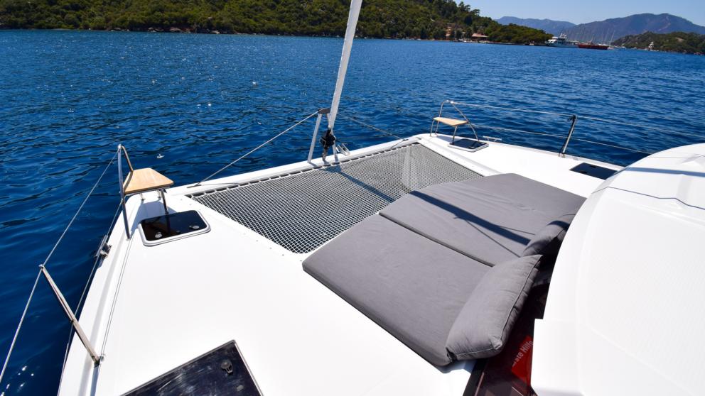 Stretched mesh and soft sunbeds on the bow of the catamaran