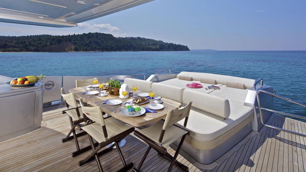 A set breakfast table on the deck of the motor yacht Thea Malta with a stunning sea backdrop in Greece.