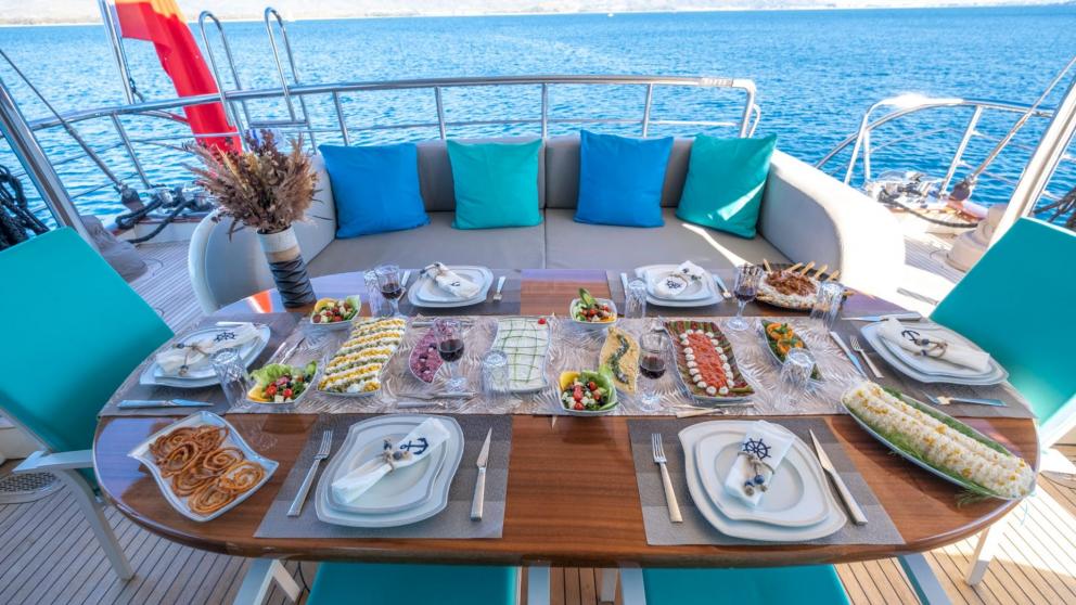 Richly set dining table with various dishes and sea view on the gulet.