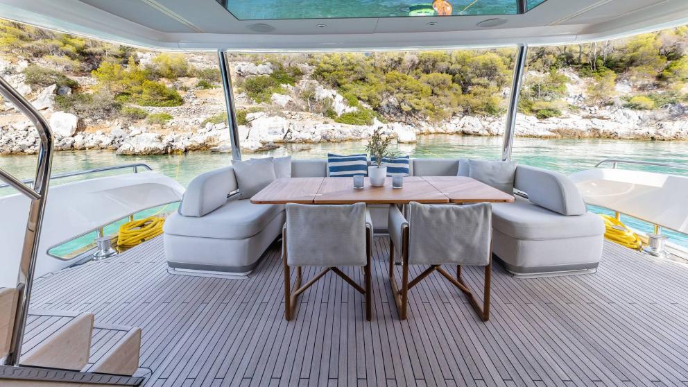Modern seating area on a yacht overlooking the Greek coastline.