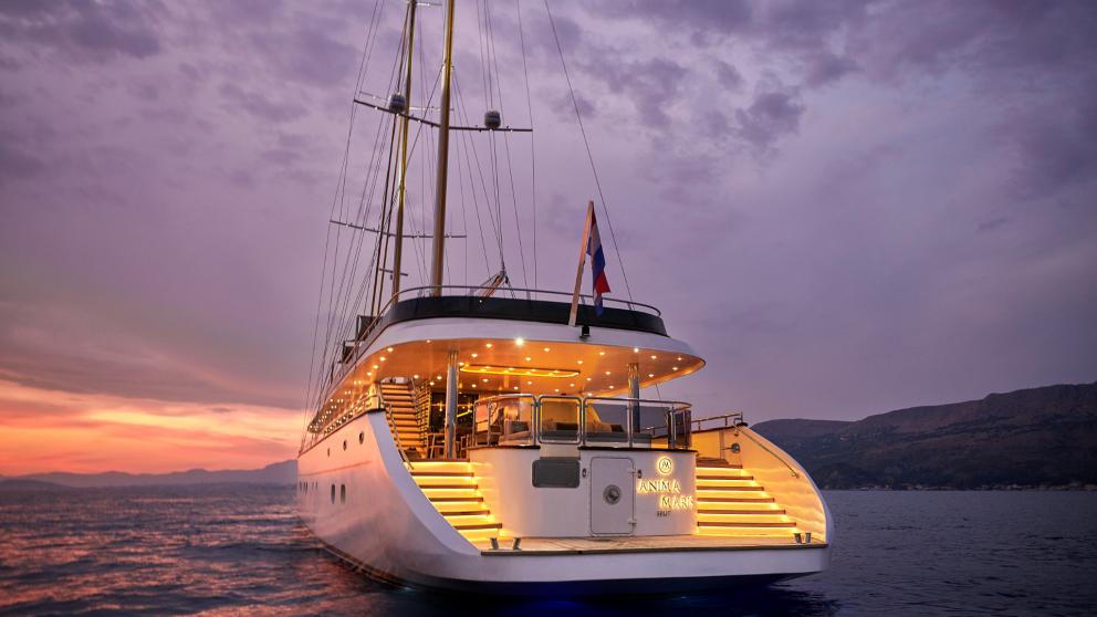 The motor sailor Anima Maris, illuminated and anchored, during a stunning sunset in Croatia.