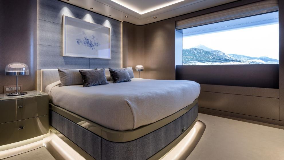 Guest bedroom on the Opari yacht with a large bed, modern decor, and sea views.