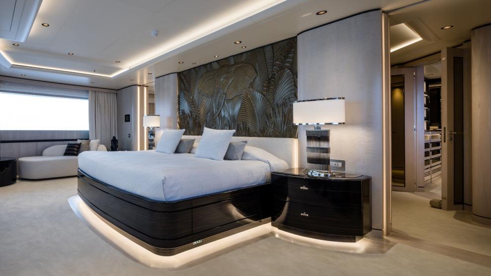 Master bedroom on the Opari yacht with a large bed, stylish lighting, and sea views.