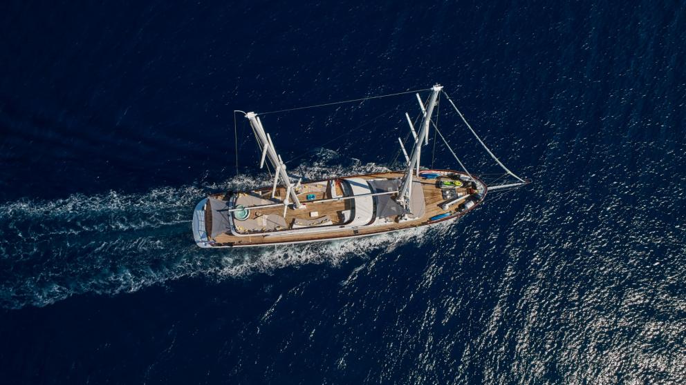 From a bird's eye view, you can see the luxury yacht in full sail on the depths of the sea.