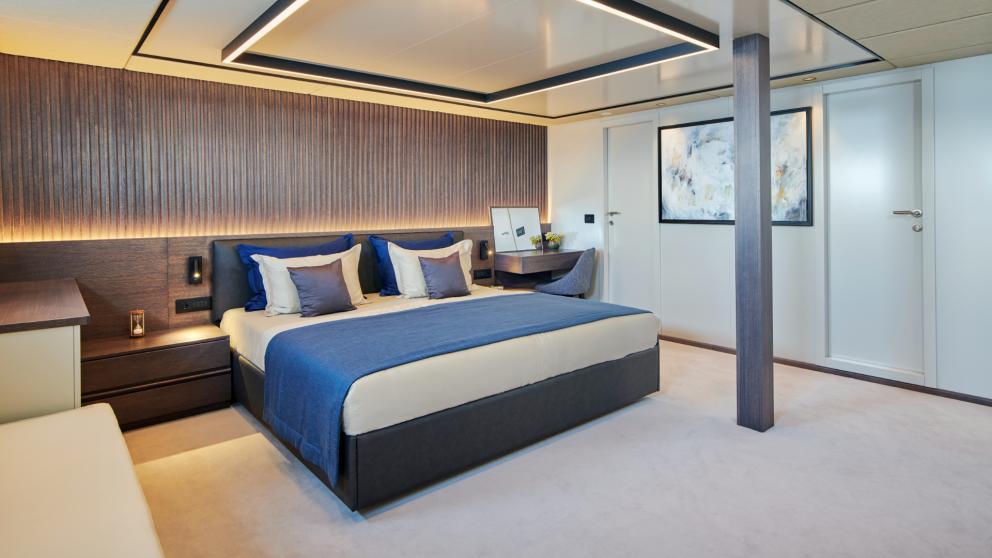 Stylish master cabin of Anima Maris with a large bed, desk, and modern decor.