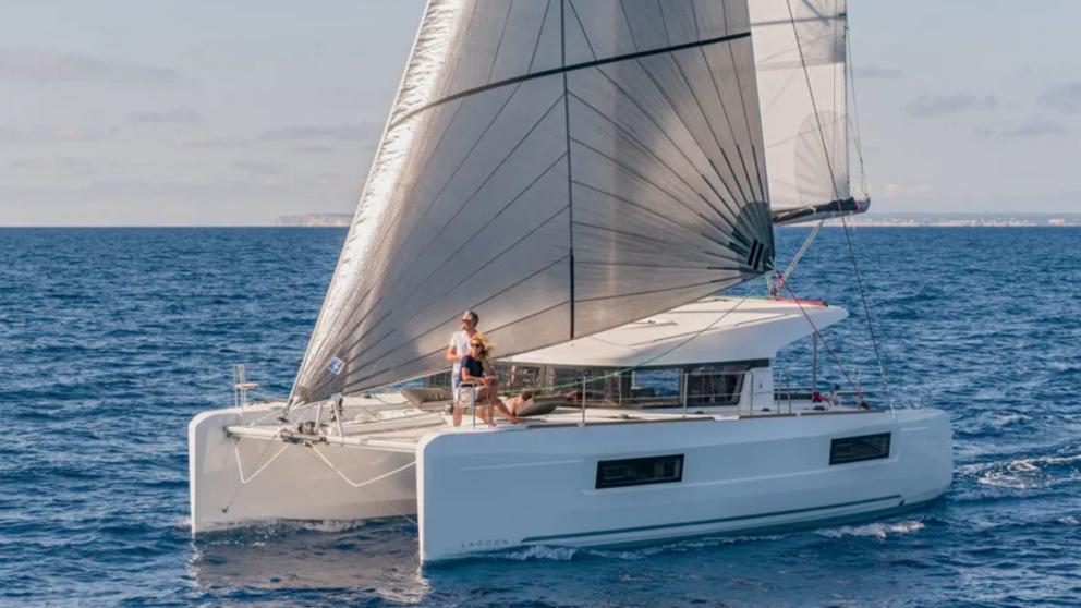 The catamaran Mithra is sailing with its sails unfurled, guests are enjoying the journey.