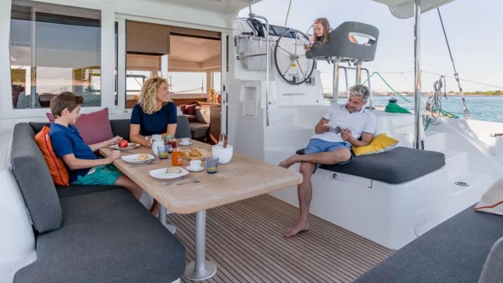 A family enjoys the yacht on the deck of the catamaran Turtle.