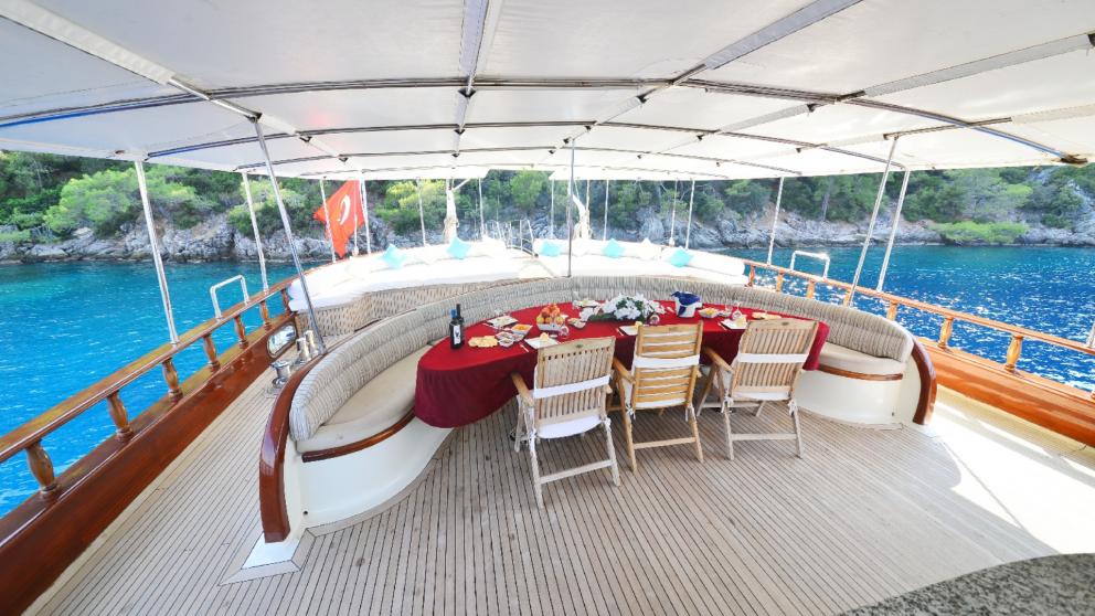 Covered dining area on the deck of the gulet Berrak Su with a view of the sea.